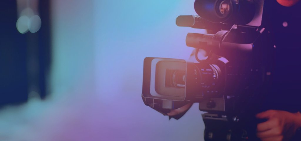 A professional video camera being operated in a studio with soft lighting