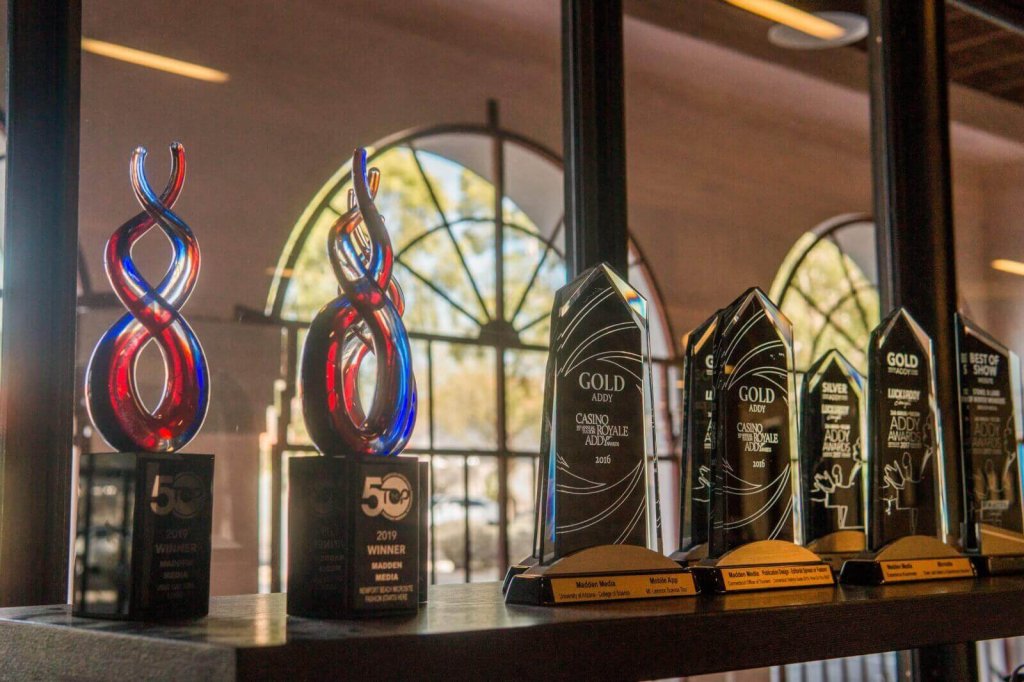 A row of various glass and crystal awards displayed on a shelf