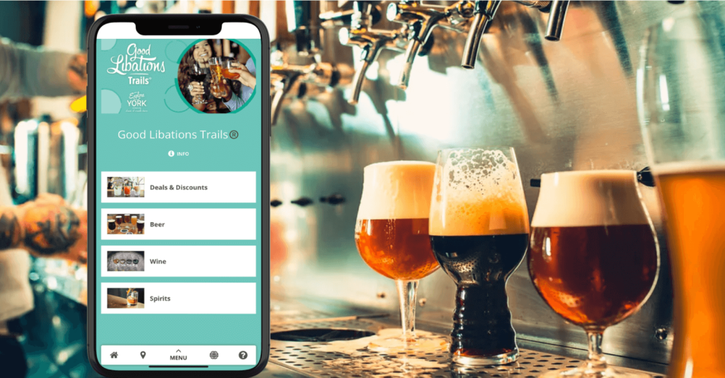 A smartphone displaying a beverage trail app in front of beer glasses on a bar