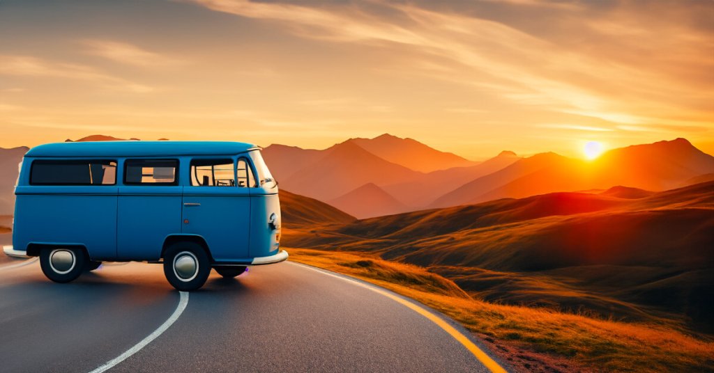 A blue vintage van parked on a winding road during a golden sunset