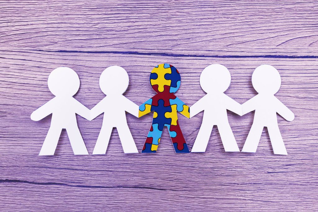 A row of paper dolls with one puzzle-patterned figure in the center