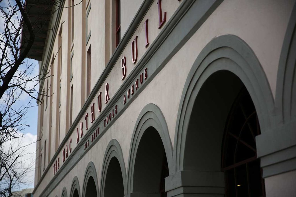 The MacArthur Building facade featuring arched windows and red lettering
