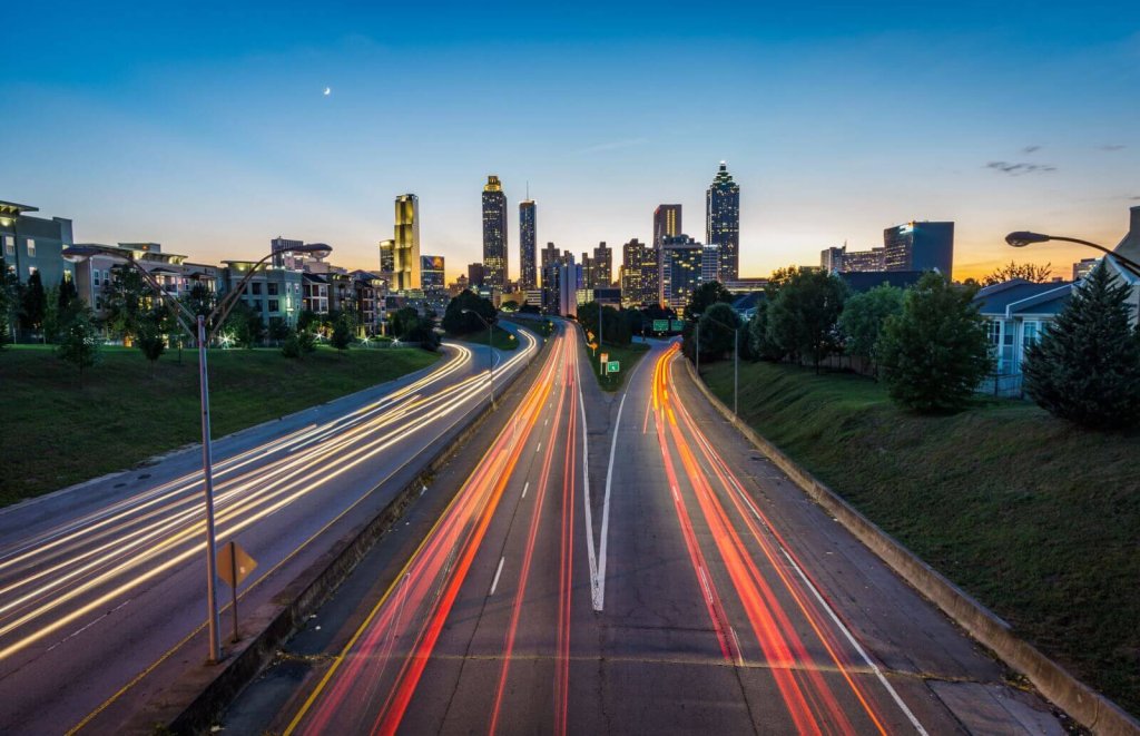 Long exposure of traffic light trails on a highway leading to a city skyline