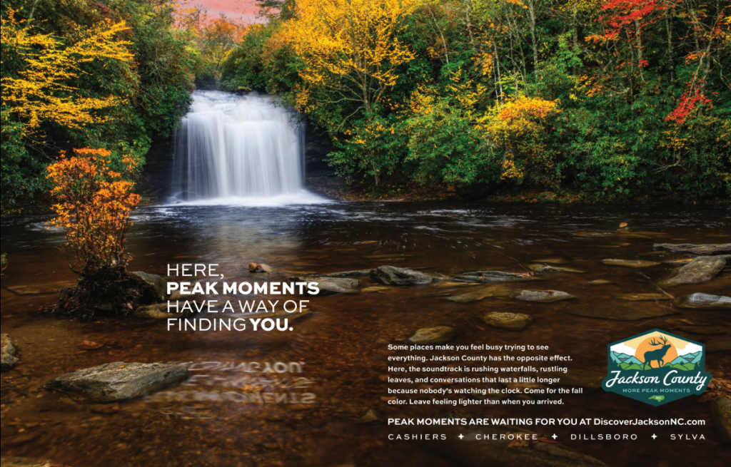 A scenic waterfall cascades into a river surrounded by vibrant autumn foliage